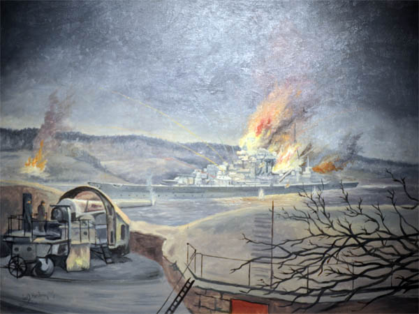 Här är konstnärens syn på kampen mellan Oscarsborg fästning och den tyska kryssaren Blucher. Tavlan hänger i kustartillerimuseet på fästningen. Kryssaren har precis blivit träffad och bensin i flygplanshangaren hat fattat eld. Här är konstnärens syn på kampen mellan Oscarsborg fästning och den tyska kryssaren Blucher. Tavlan hänger i kustartillerimuseet på fästningen. Kryssaren har precis blivit träffad och bensin i flygplanshangaren hat fattat eld.