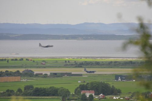 Flygbasen med plan på marken och i luften, sett från Löberen.